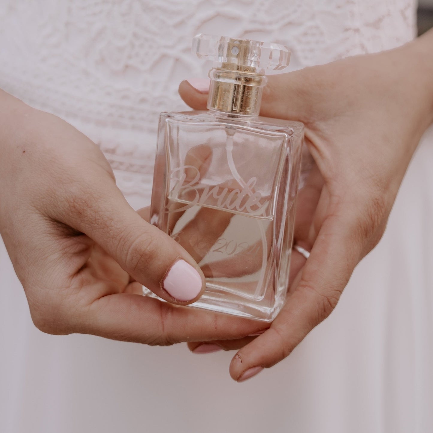 een vrouw die een gepersonaliseerd parfumdlacon in haar handen heeft met de tekst Bride en daaronder de trouwdatum.