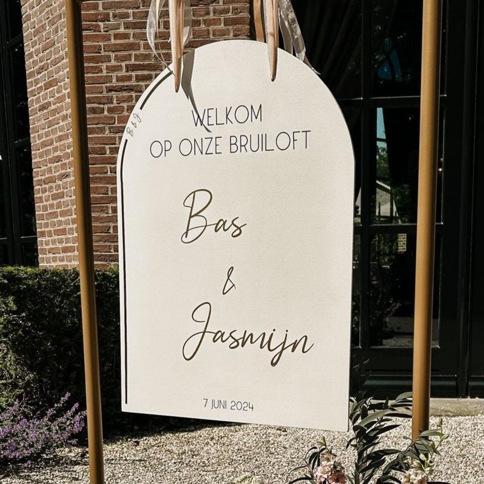 ingezoomd prachtig elegant en minimalistisch welkomstbord met ronde boog. bedrukt met sierlijke gouden letters.
